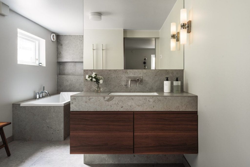 Stilrent badrum i grå sten och trä - Dekå totalrenoverar din lägenhet i Stockholm