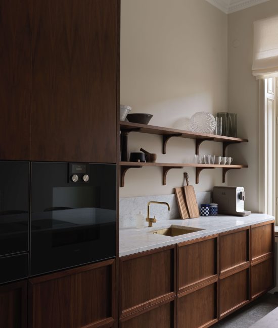 Stilrent kök i trä och ljus marmor som matchar resterande rum i lägenheten - Dekå hjälper dig totalrenovera din lägenhet i Stockholm